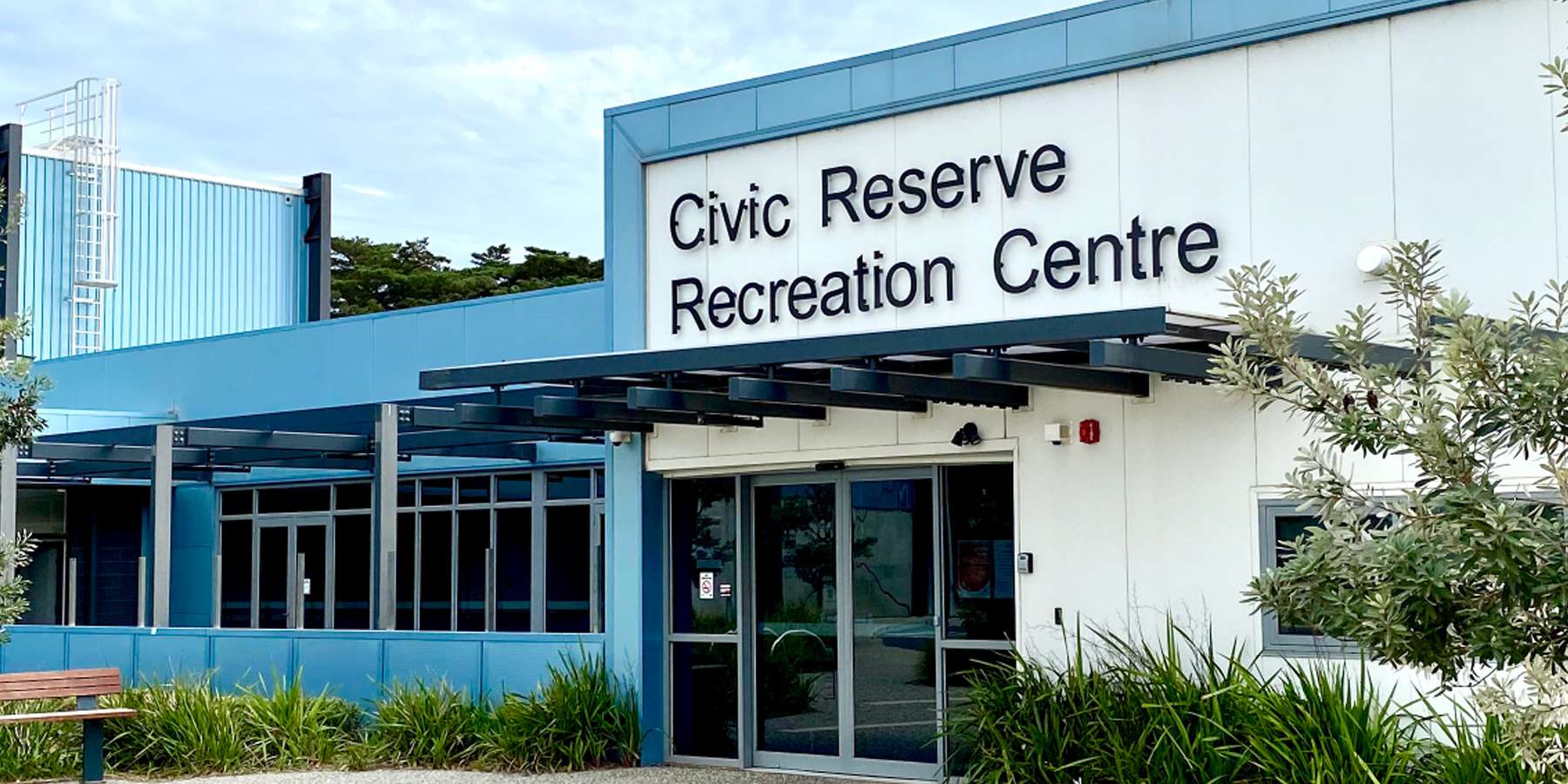 Exterior view of the Civic Reserve Recreation Centre featuring large windows and a welcoming entrance, surrounded by greenery.
